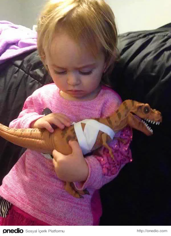 Yaralanan dinozoruna önce ilk yardım uygulayıp ardından onu teskin etmeye çalışan bu minik kız.